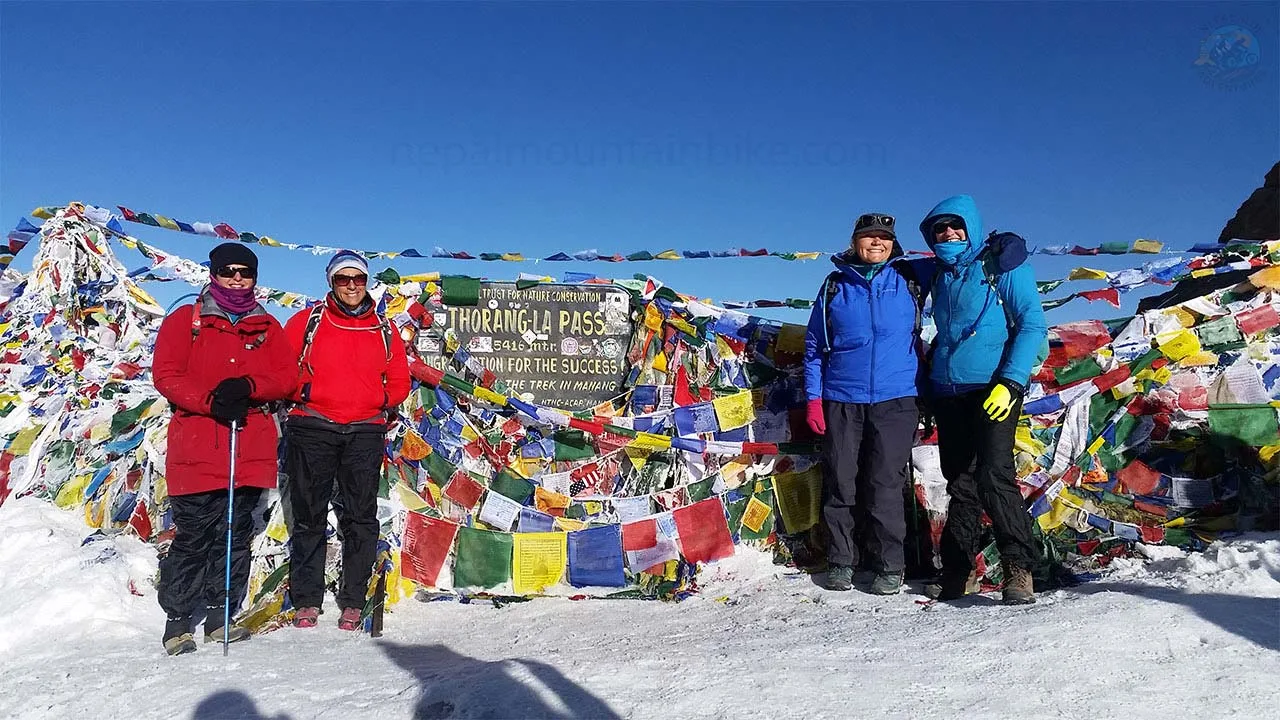 Trekkers on the top of Thorong-La pass at an altitude of 5416 m are taking picture during trekking adventure in Nepal.